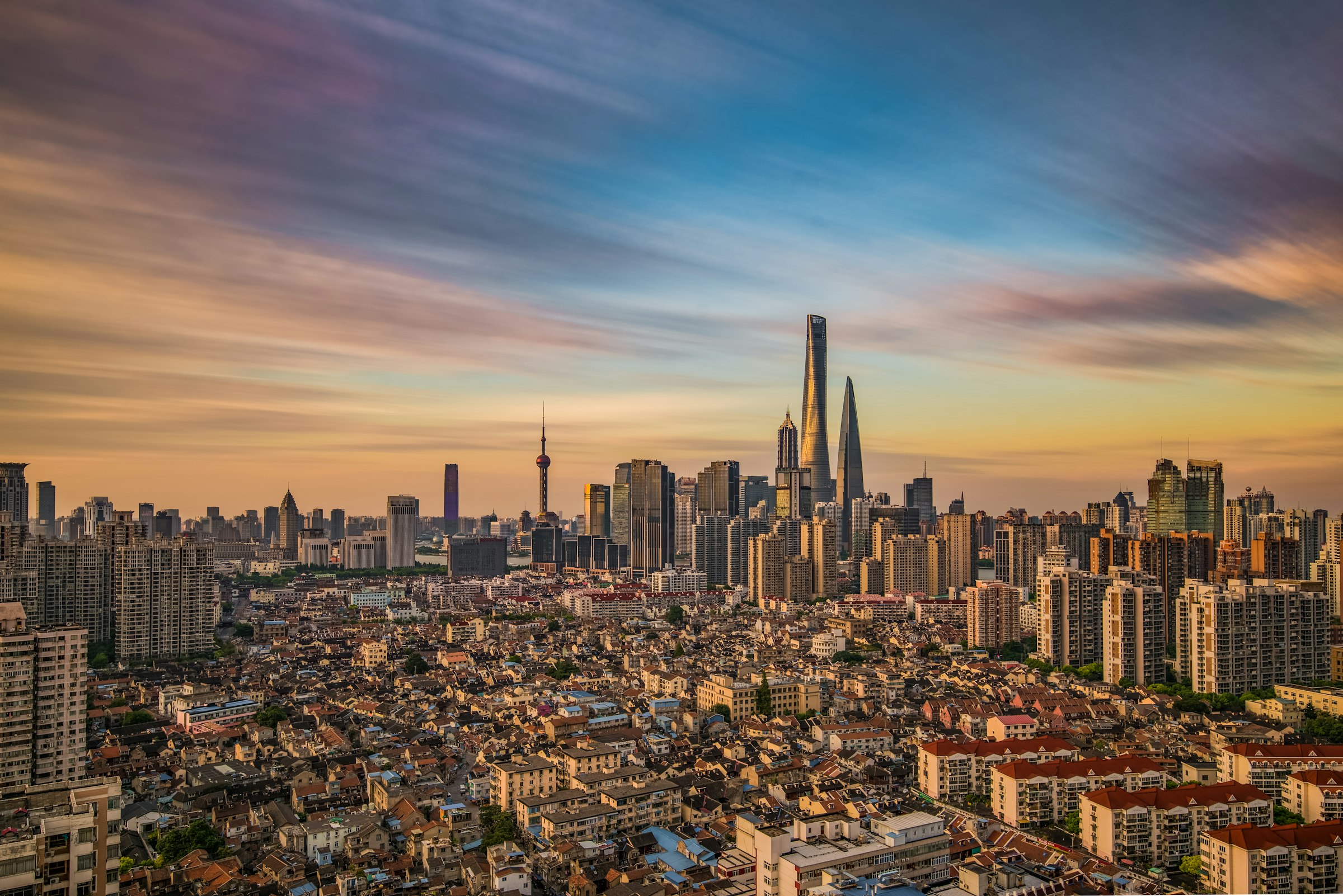 Shanghai's skyline over low-rise neighbourhoods at sunset